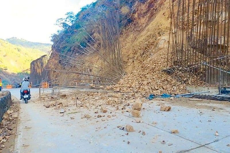 Motorcycle riders drive past a collapsed retaining wall along Kennon Road (May 9, 2023).
