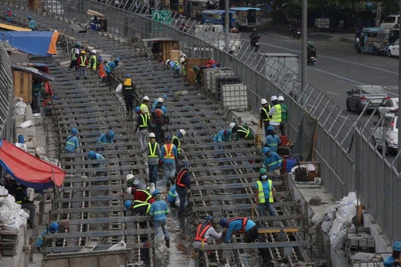 Workers continue construction duties despite the heat along Commonwealth Avenue in Quezon City on April 26, 2023.