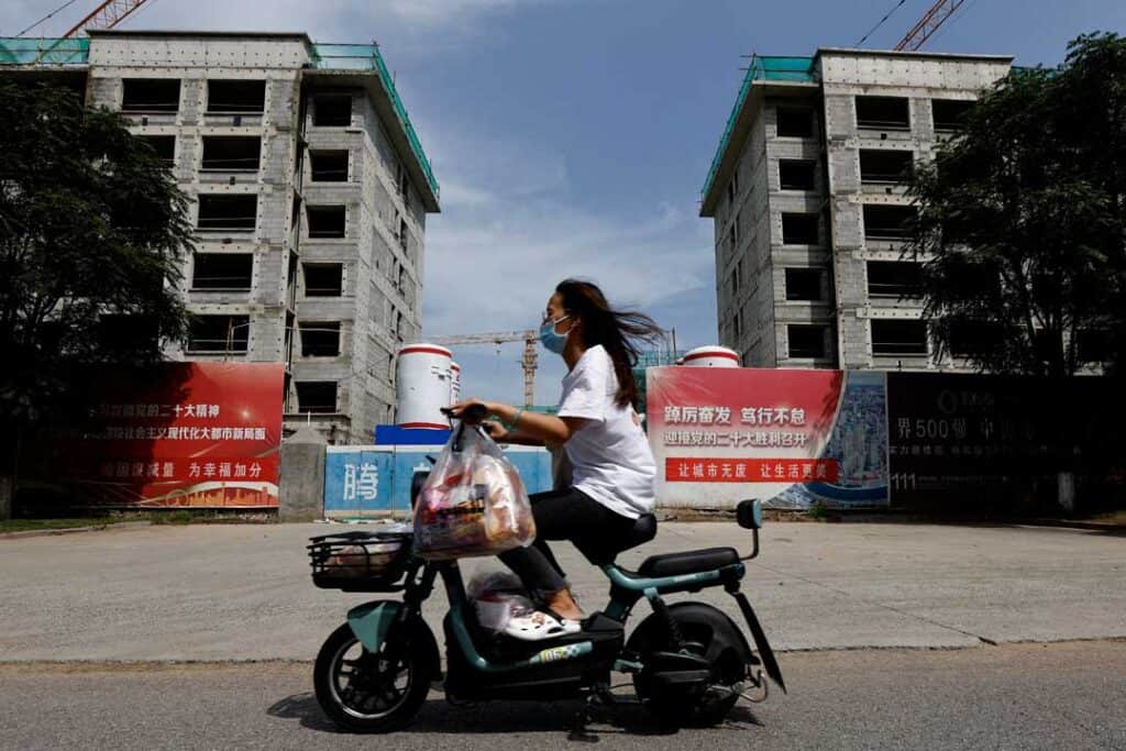 A person rides a scooter past a construction site of residential buildings by Chinese developer Country Garden, in Tianjin, China Aug. 18, 2023. — REUTERS/TINGSHU WANG
