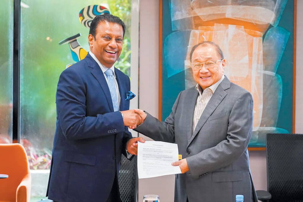 Manuel V. Pangilinan (right), MPIC chairman, president and chief executive officer, signs a memorandum of agreement with Tan Sri Ravindran Menon, Hartasuma’s group executive director.
