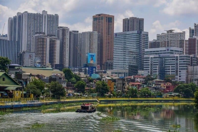 A tug boat sails along the Pasig river before high-rise buildings of the Makati business district in Manila on May 29, 2022.
