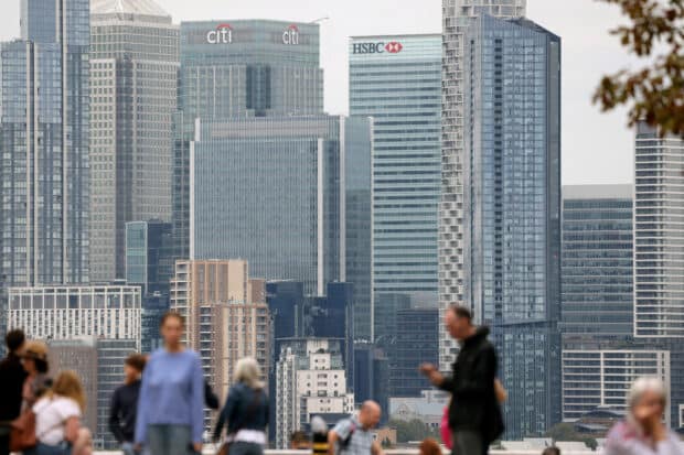 People stand at Greenwich Park, with the Canary Wharf financial district in the distance, in London, Britain, Aug 29, 2023.