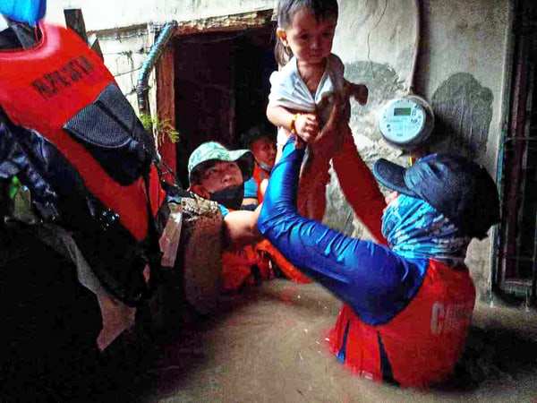 RESPONDERS rescue a child in a flood spawned by typhoon ‘Odette’ in Northern Mindanao. (Photo courtesy of PNP chief Police Gen. Benjamin Acorda Jr.’s Facebook page)
